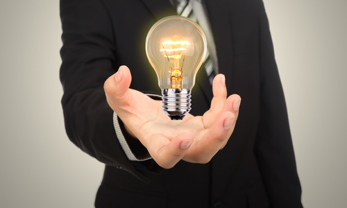 Business man holding light bulb